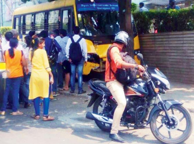 Passers-by stop to look at the damaged bus