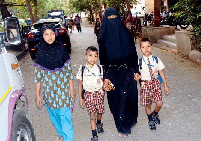 Sajida (right, in burqa) with daughter Zara and sons Inayat and Ejaz