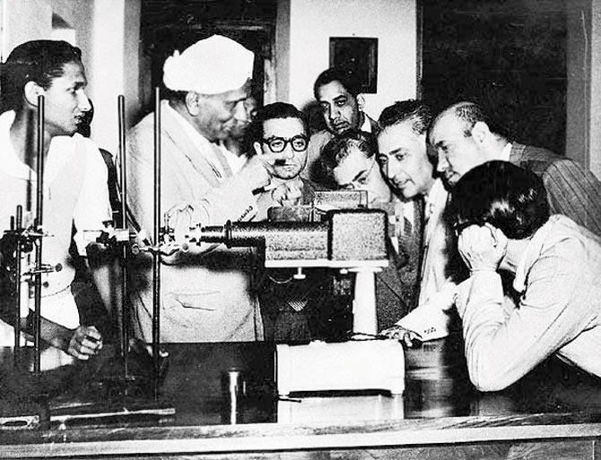 C V Raman showing the spectrometer to students