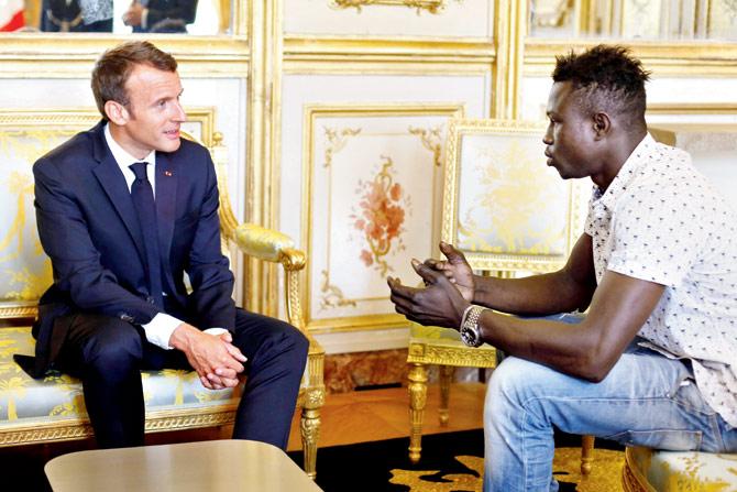 Emmanuel Macron with Mamoudou Gassama (right). Pic/AFP