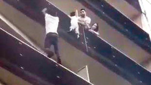The video shows Gassama pulling himself up from balcony to balcony