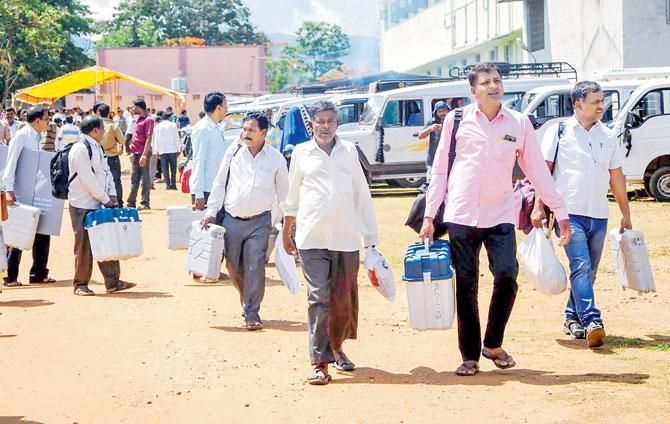 Polling officials collect EVMs and other election material on the eve of Karnataka Assembly elections in Chikmagalur. Pic/PTI