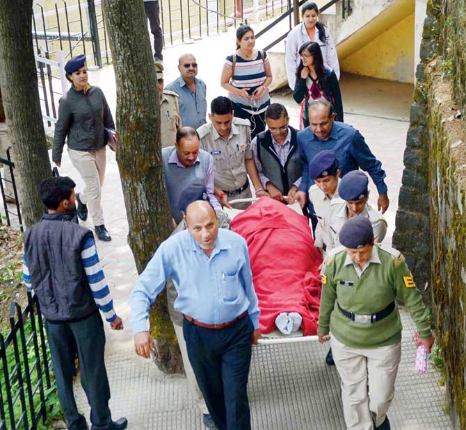 Police personnel carry the body of Shail Bala Sharma for post-mortem at IGMC hospital. Pic/PTI