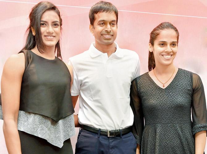 PV Sindhu and Saina Nehwal with coach P Gopichand in New Delhi on Saturday. Pic/PTI
