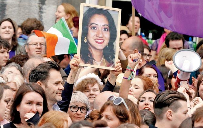 People hold up a photo of Savita Halappanavar at Dublin Castle while celebrating. Pic/AFP