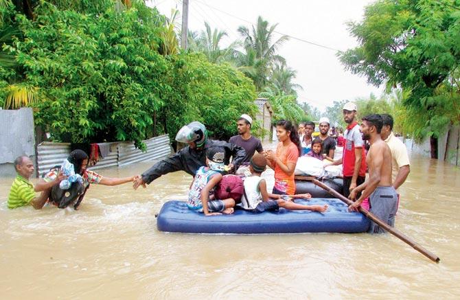 Sri Lankans make their way to an inflatable raft to move to safer ground on the outskirts of Puttalam. Pic/AP