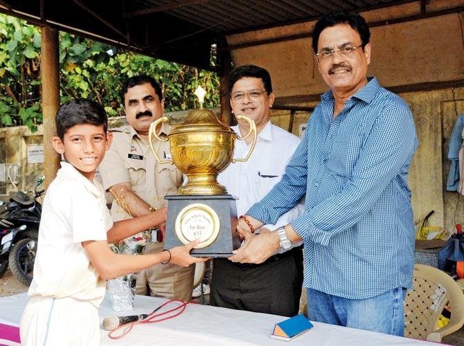 Vengsarkar Academy captain Yasin Saudagar receives the Tulpule Cup from ex-India skipper Dilip Vengsarkar