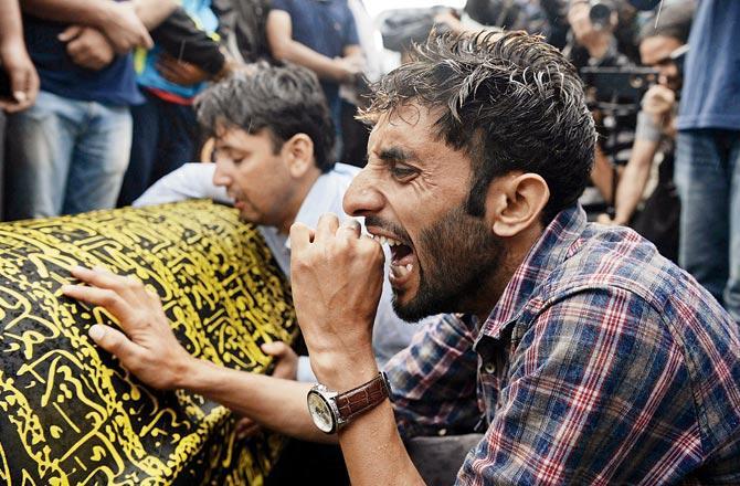 Shujaat Bukhari: Veteran journalist and Rising Kashmir editor Shujaat Bukhari and his PSO were shot dead by unidentified gunmen outside the newspaper's office in Srinagar on June 15, 2018. Bukhari was instrumental in organising several conferences for peace in the Kashmir Valley. He earlier worked with The Hindu as its Kashmir correspondent. Bukhari's body was spotted lying in a pool of blood near the newspaper's office.In the file photo, relatives of slain editor-in-chief of a Srinagar-based newspaper Rising Kashmir Shujaat Bukhari mourn near his coffin at Kreeri. Pic/AFP   