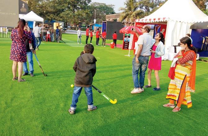 Children try their hand at some hockey at the Fan Village in the Kalinga Stadium yesterda