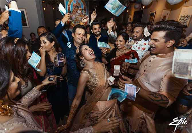 This photograph from the sangeet ceremony will be a historic one from Prince Narula and Yuvika Chaudhary's sangeet function. Everyone is seen dancing their hearts out in the frame. While we have heard of flashing a million-dollar smile, here, we see million dollars being flashed, quite literally!