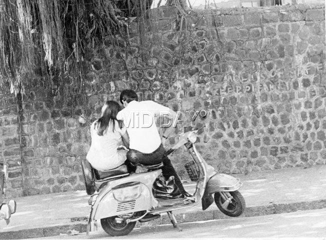 A young couple enjoys a quiet moment on a scooter in a vintage photo taken by mid-day photographer    