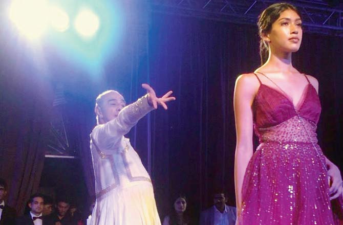 Astad Deboo gestures as a model walks the ramp