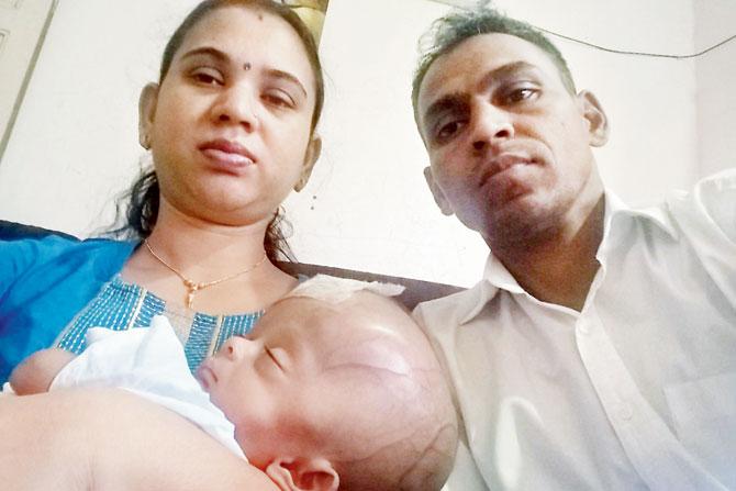 Eliza in the arms of her parents, Anand and Jayanti Waghmare