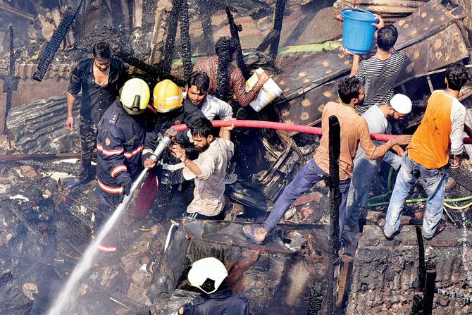 A joint team of fire brigade, civic staffers and Mumbai Police personnel were mobilised to douse the flames at Nargis Dutt Nagar slum on Tuesday. Pics/Shadab Kha