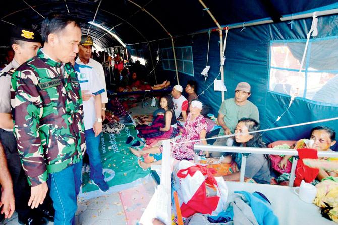 Indonesian Prez Joko Widodo (L) talks with survivors