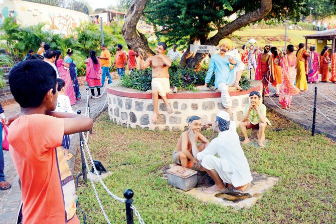 Visitors enjoy the life-size sculptures depicting village life
