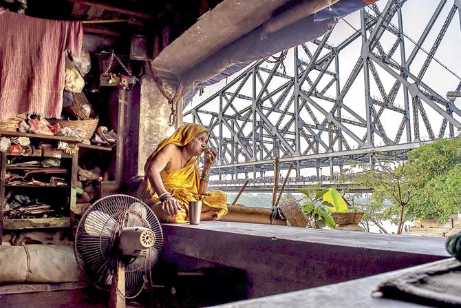 Bengalis can have endless cups of tea. Here, a woman spends a contemplative moment sipping on the beverage next to Howrah Bridge