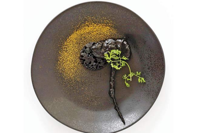 Painted in a sleak black south Indian pepper sauce with black rice pancake