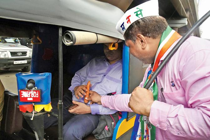 An MNS worker gives a carrot to a passenger in a rickshaw during the bandh. Pics/Nimesh Dave