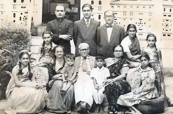 Portrait of Dr Gopalrao Deshmukh (seated centre) with his family in the front garden of their bungalow: left to right are his granddaughters Anandi and Jyotsna, and daughter Sushila Pandit with her son Ravi, grandson Atchut Talwalkar with his mother Kamal and sister Asha, behind whom are Deshmukh