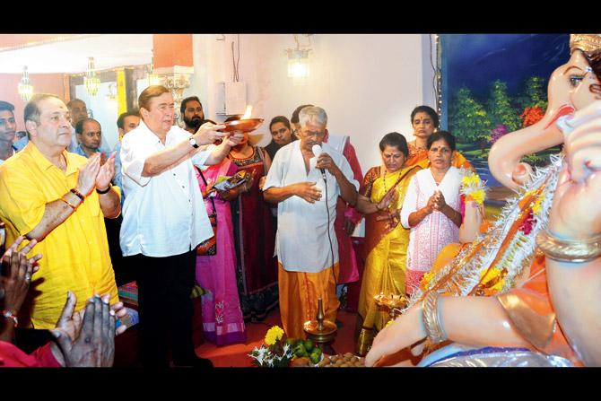 Rajiv and Randhir Kapoor with guests and staffers at the aarti