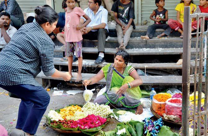 The flower vendor happily hands over her wares inside a plastic bag. Pic/Datta Kumbhar