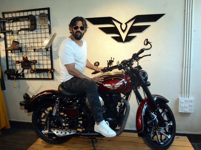 Suniel Shetty posed for shutterbugs on a bike at the store launch in Goregaon, Mumbai. The actor was casually dressed in camo pants, a white t-shirt and a pair of white sneakers.