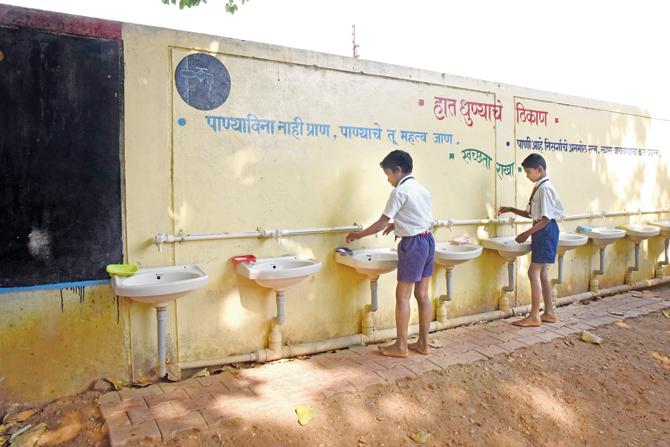 Students use the wash basins that teachers constructed for them