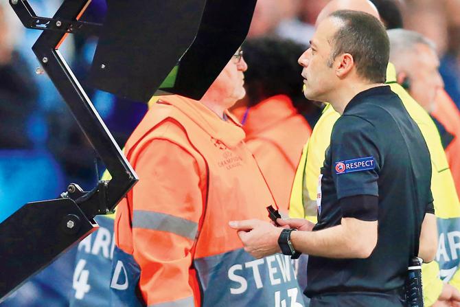 Referee Cuneyt Cakir refers to the VAR screen before allowing Llorente