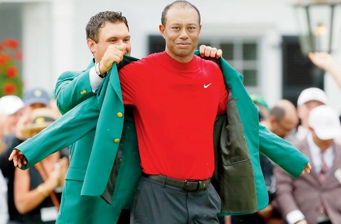 Augusta Masters winner Tiger Woods is awarded the Green Jacket by last year’s champion Patrick Reed (left) on Sunday. Pic/AFP