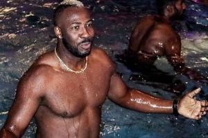 Andre Russell shows off his muscles in the swimming pool