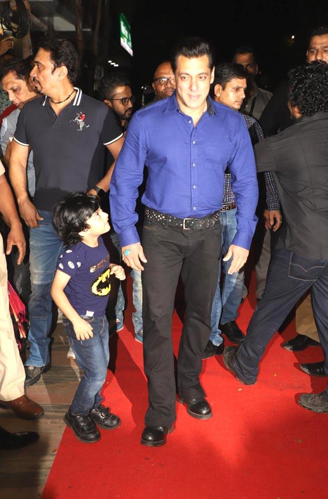 Salman Khan looked stylish in a pair of black trousers paired with a royal blue shirt and his signature bracelet. Pictured here is Sallu Bhai with a little fan. 