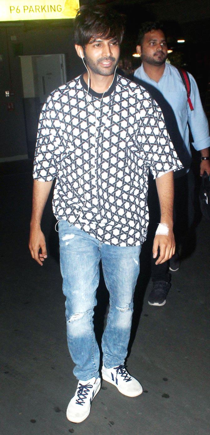 Kartik Aaryan was spotted looking weary at Mumbai airport. The actor chose a printed oversized t-shirt and blue jeans for his travels.