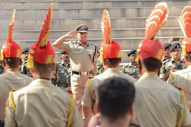 Indian Border Security Force (BSF) commandant Mukund Kumar Jha (C) salutes during a flag hosting ceremony to celebrate the country's 73rd Independence Day, which marks the end of British colonial rule