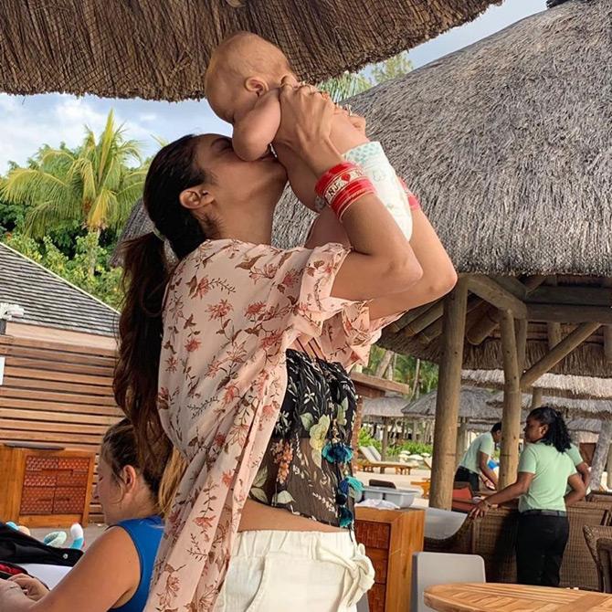 In picture: Nusrat Jahan, who is seen sporting a floral black crop top looks adorable as she plays with a small child during her beach vacation in Mauritius
