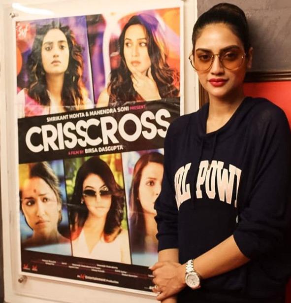 In this photo, Nusrat Jahan poses with a movie poster in the background in a black hoodie with 'Girl Power' written on it. Nusrat accentuated her look with lipstick and tied her long tresses in a bun