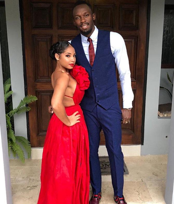 Usain Bolt is a Jamaican former sprint legend who holds the record in 100 metres, 200 metres as well as 4 × 100 metres relay.
In pic: Usain Bolt looks dapper in a navy blue waistcoat and matching trousers while Kasi Bennett looks glamorous in her long red gown