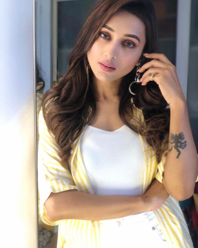 In pic: Mimi Chakraborty gets sun-kissed while posing at the Delhi Airport as she stuns in a simple yellow and a white stripe shirt and a white tee.