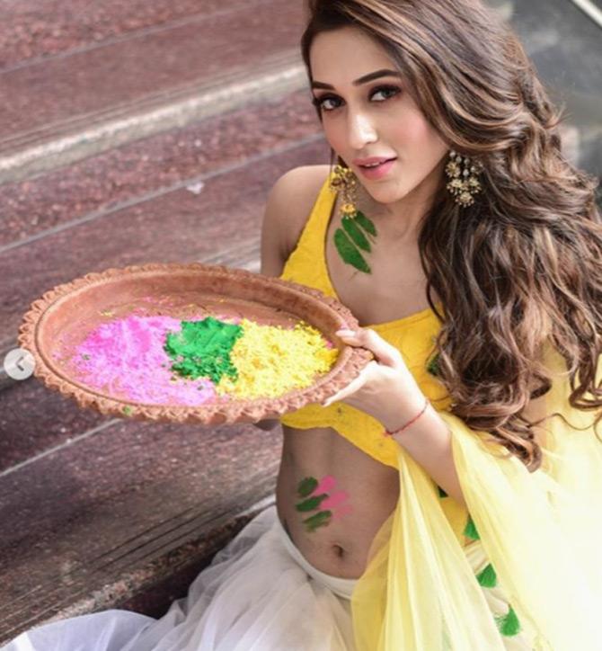 Mimi Chakraborty who is seen sporting a yellow sleeveless yellow blouse as she pairs it with a white lehenga skirt. She completes her festive look with pretty earrings and leaves her long curled tresses open. Mimi captions this one: Happyyyyyy Holi!
