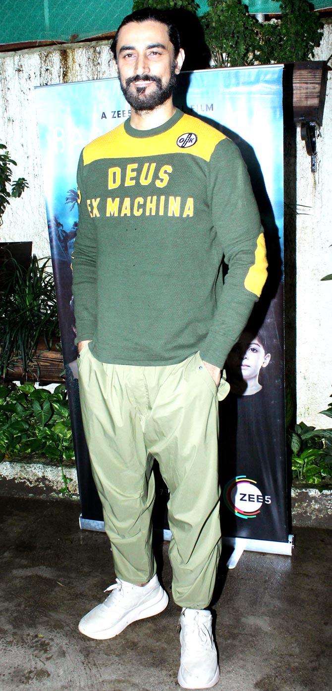Kunal Kapoor poses for the photographers as he arrives for the special screening of Barot House in Juhu.
