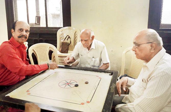 Chunilal Panchal, 102 (centre), strikes a shot at the carrom board. The ex-wrestling judge walks every evening from his Tardeo home to the senior citizens