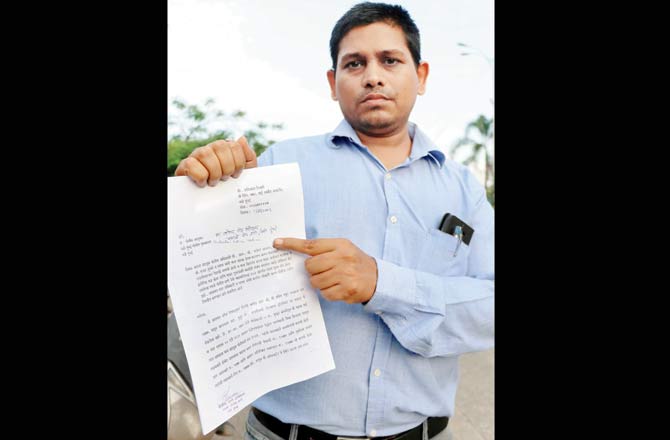 Shashikant Tiwari shows his complaint letter to the police