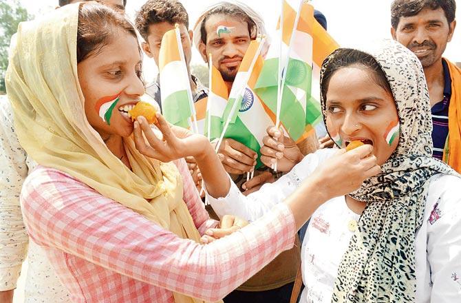 Women celebrate with sweets near the India-Pakistan Wagah Border about 35 km from Amritsar, on Monday. Pics/AFP