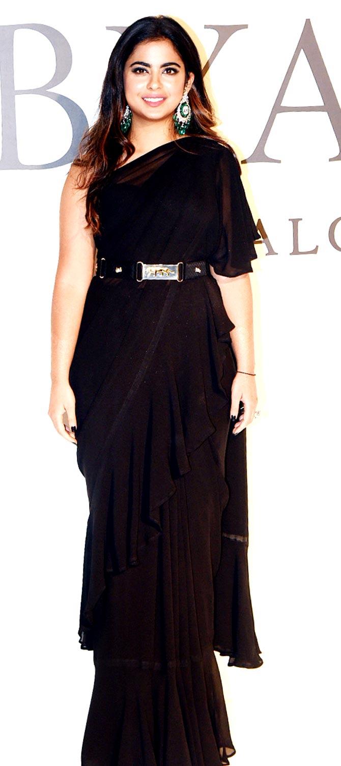 Isha Ambani stuns in a ruffled black sari-gown during a fashion event in Mumbai. Isha paired her saree with a belt, thereby accentuating her look. Isha completed her look with pretty diamond and emerald earrings