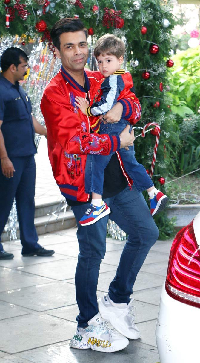 Karan Johar attended Taimur Ali Khan's birthday bash with son Yash Johar. Karan twinned with son Yash in a red bomber jacket and blue denim.