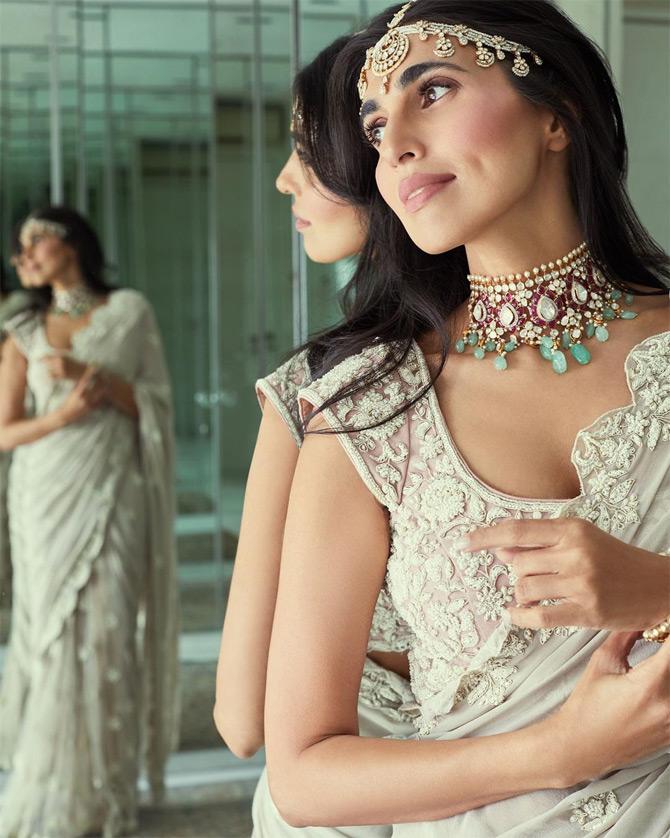 The dimpled beauty poses with elegance wearing a georgette sari with a maathapatti and a statement choker