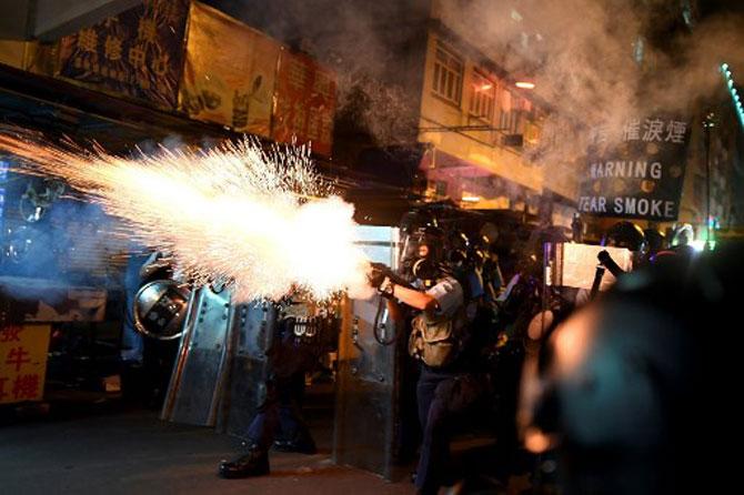 Police personnel fire tear-gas shells to disperse Pro-Democracy protestors in the Sham Shui Po Area of Hong Kong on August 14, 2019. More than 10 weeks of sometimes-violent demonstrations have wracked the semi-autonomous city, with millions taking to the streets to demand democratic reforms and police accountability.