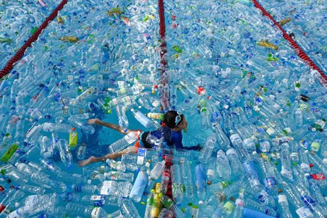 A child swims in a pool filled with plastic bottles during an awareness campaign to mark the World Oceans Day in Bangkok on June 8, 2019.