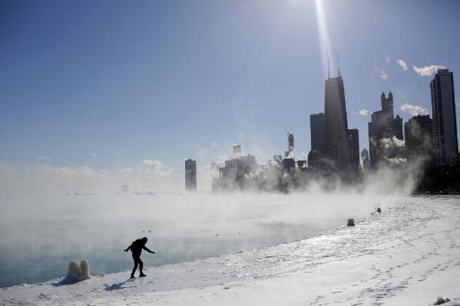 Marius Radoi keeps his balance as he walks on the edge of Lake Michigan's shoreline as temperatures dropped to -20 degrees F (-29C) on January 30, 2019, in Chicago, Illinois. Frostbite warnings were issued for parts of the US Midwest on January 30, 2019, as temperatures colder than Antarctica grounded flights, forced schools and businesses to close and disrupted life for tens of millions.