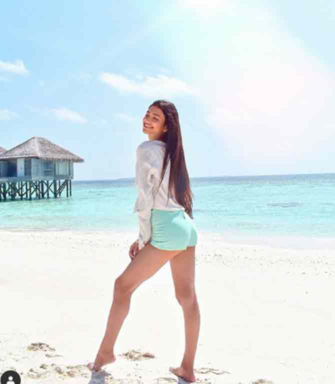 Alanna Panday is often seen to be on vacation. Here, she shines in a white loose shirt and light blue denim shorts besides a beach in Maldives.